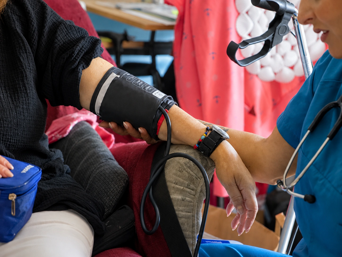 Nahaufnahme: Pflegekraft legt einer Patientin die Manschette zur Blutdruckmessung an