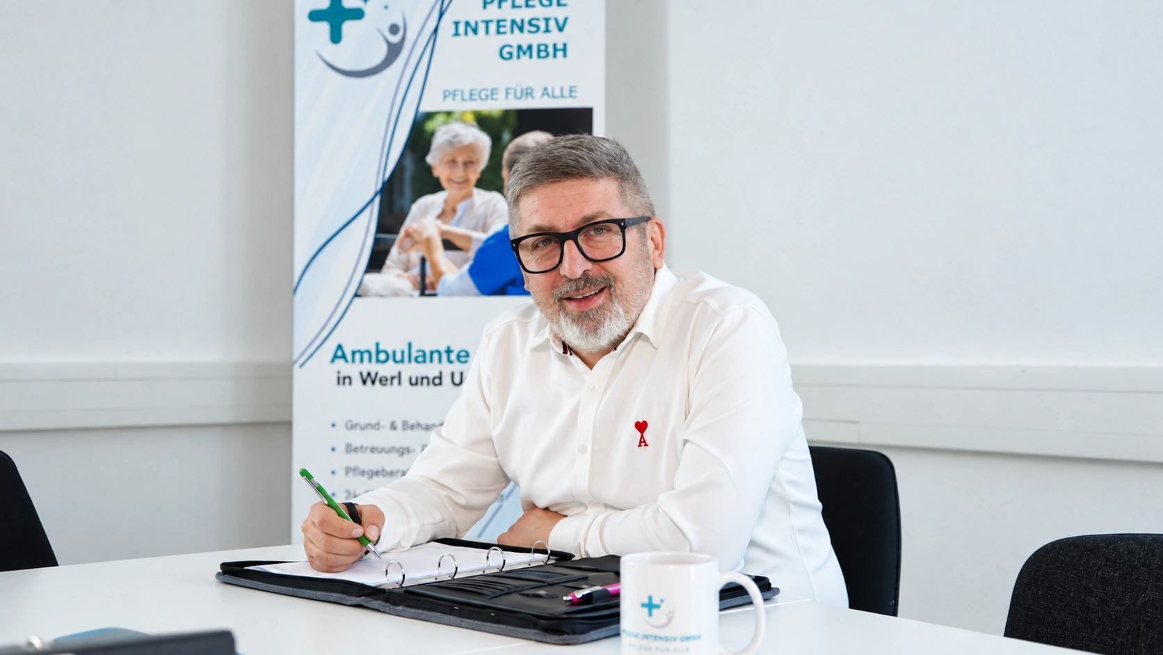 Mitarbeiterin oder Mitarbeiter der Pflege Intensiv GmbH am Besprechungstisch